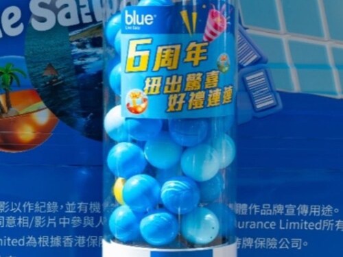 圓柱扭蛋機貼上藍色品牌周年活動貼膜，機內裝滿深淺不一的藍色扭蛋